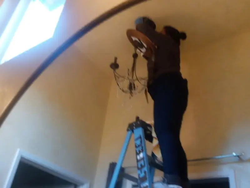 Electrician installing a chandelier in a Morro Bay residence